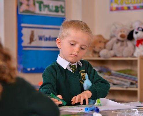 Pupil at St Andrews Primary School drawing picture at desk