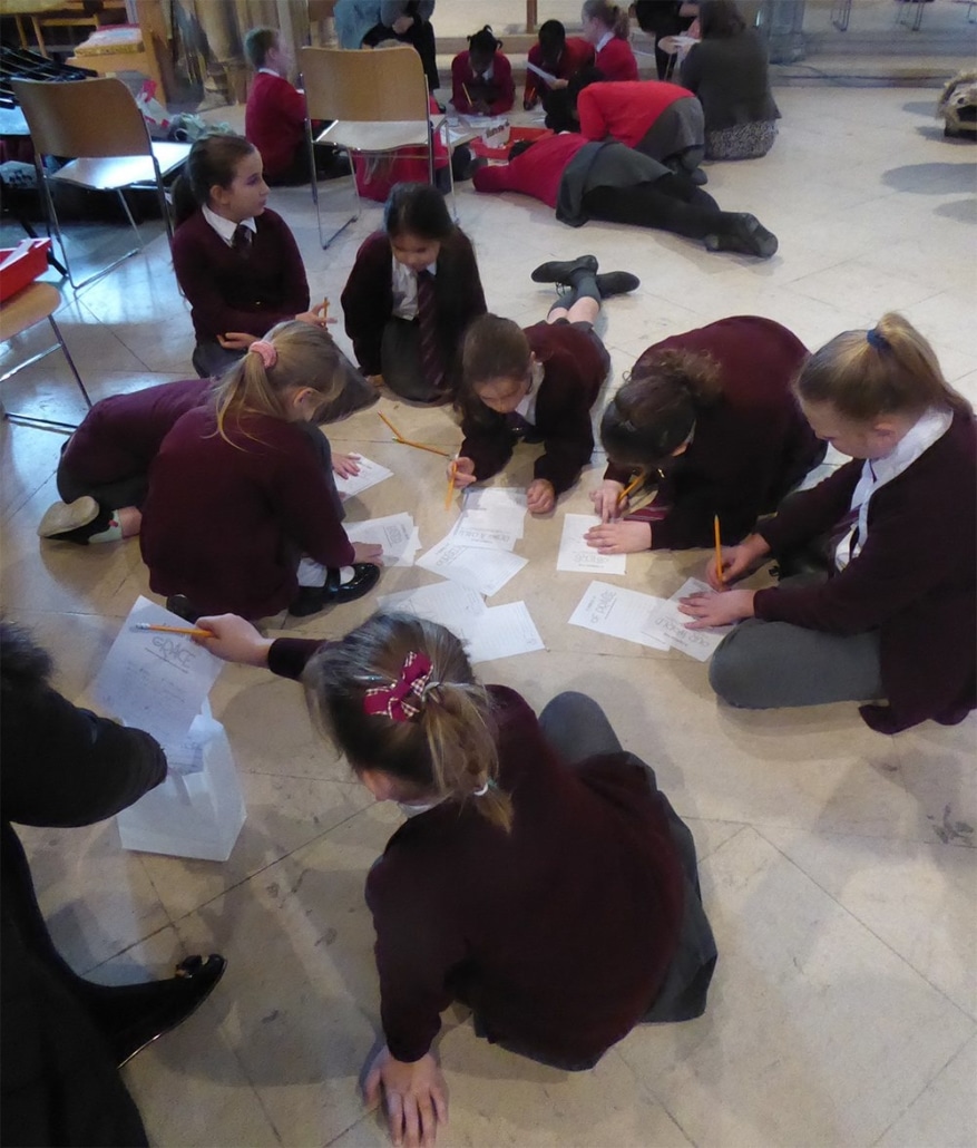 Pupils sat in a circle writing on paper